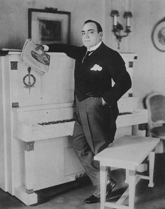 Enrico Caruso beside his piano