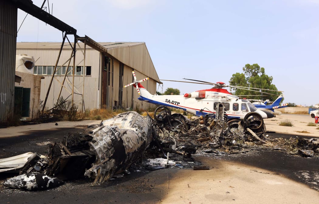 The charred remains of a plane at  Tripoli aiport following Monday's attack.