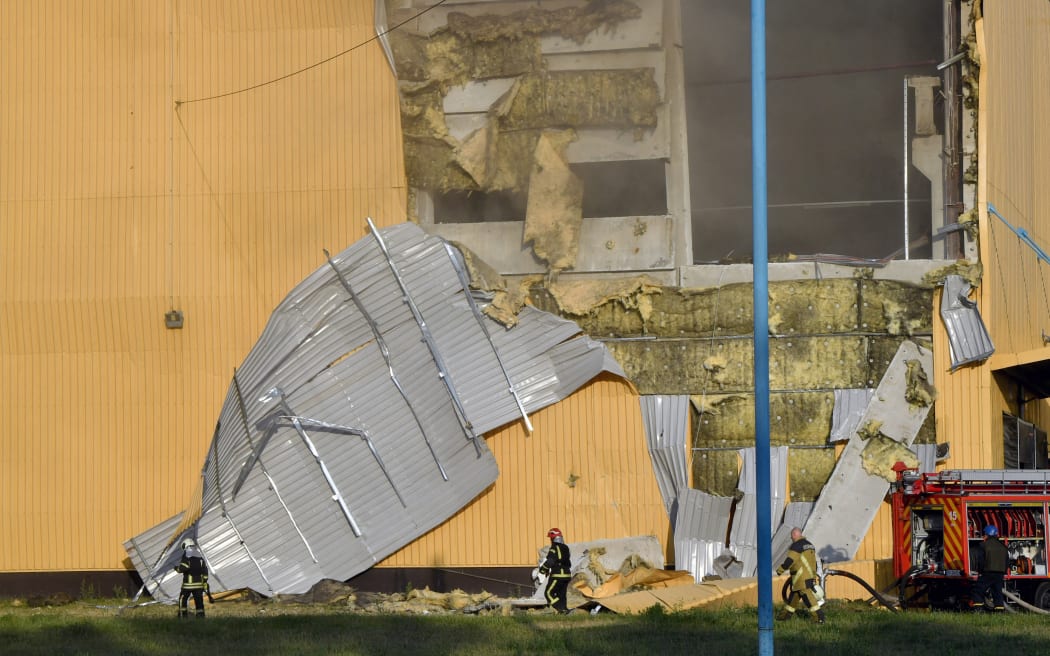 Rescuers put out the fire in an industrial facility after a massive Russian drones strike mainly targeting the Ukrainian capital, in Kiyv, on May 28, 2023. Russia carried out the "most important" drone attack on Kyiv in the night of May 27, since the start of the invasion, military authorities said. "In total a record number of explosive drones launched were counted: 54!" Ukraine's air force said in a Telegram post. Forty of the drones targeted the capital, killing two people and wounding three. (Photo by Sergei SUPINSKY / AFP)