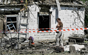 An elderly woman stands outside a house after the owner is killed by a Russian missile attack in the Zaporizhzhia region, Ukraine, on August 26, 2024. NO USE RUSSIA. NO USE BELARUS. (Photo by Ukrinform/NurPhoto) (Photo by Dmytro Smolienko / NurPhoto / NurPhoto via AFP)