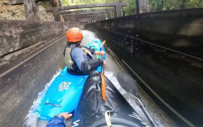 Jerremy Norbury (front) and friend Zack Mutton kayaking down a drainage ditch in Hokitika.