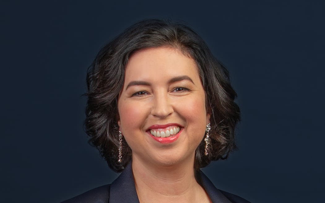 Clarissa Dunn smiles broadly, she is wearing navy blouse and jacket