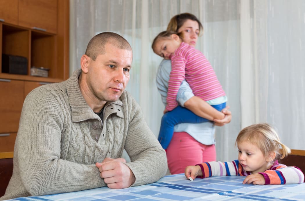 A picture of an emotionally distant father at home ignoring his family