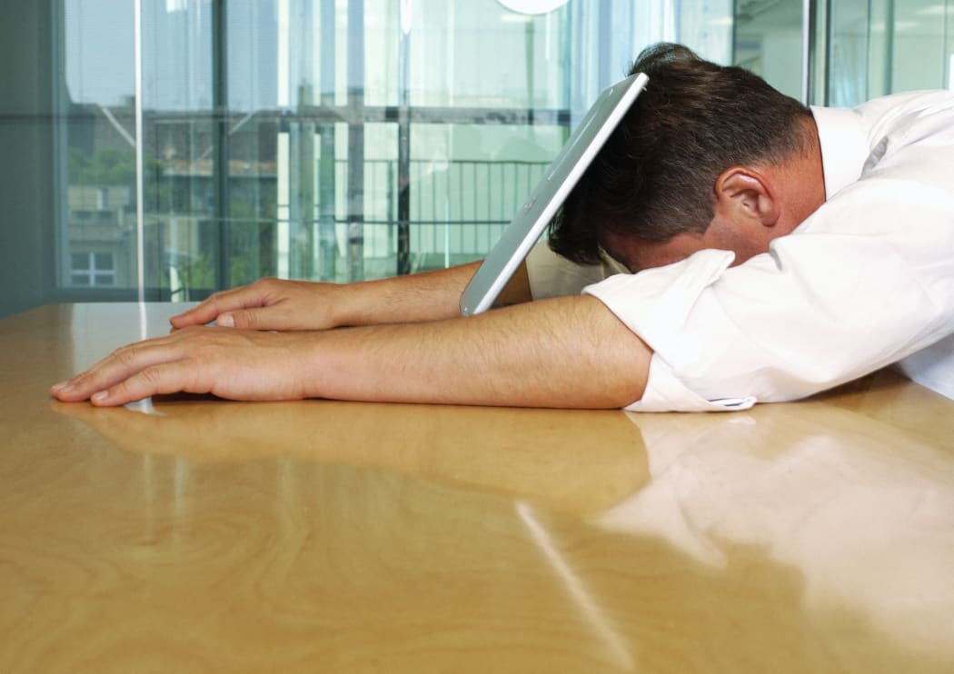 Businessman lying with face on laptop. (Photo by Téo Lannié / AltoPress / PhotoAlto via AFP)