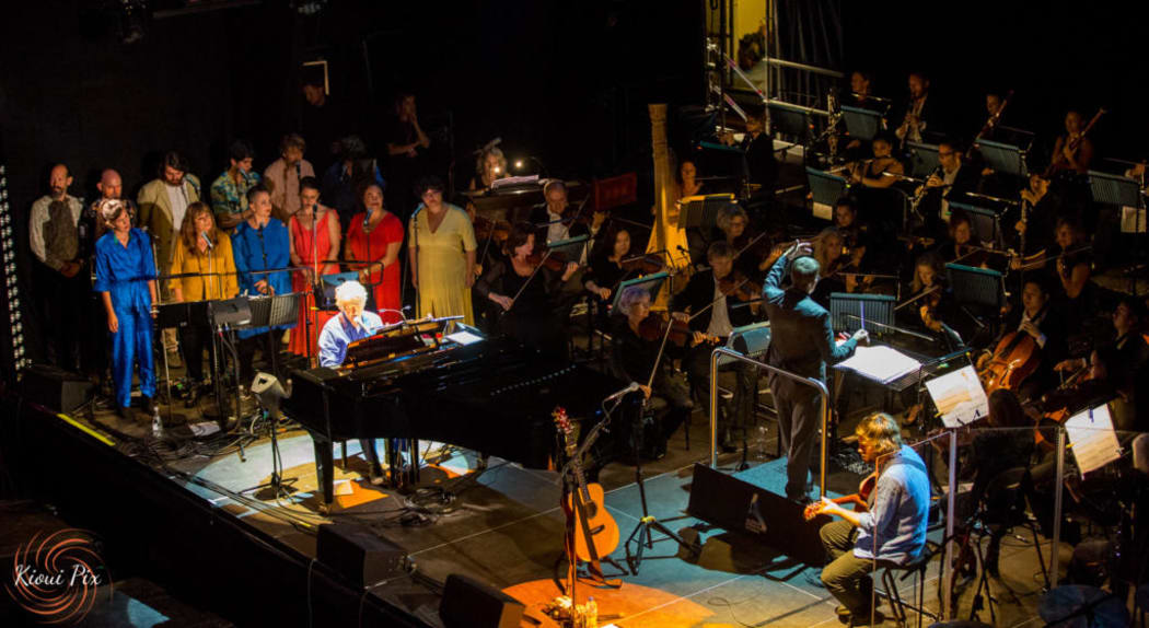 Neil Finn and APO on stage.