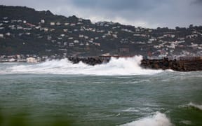 Waves crash against a sea wall near the end of Wellington Airport