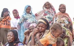 Sudanese refugees from the Tandelti area who crossed into Chad, in Koufroun, near Echbara, gather on 30 April 2023 for an aid distribution.