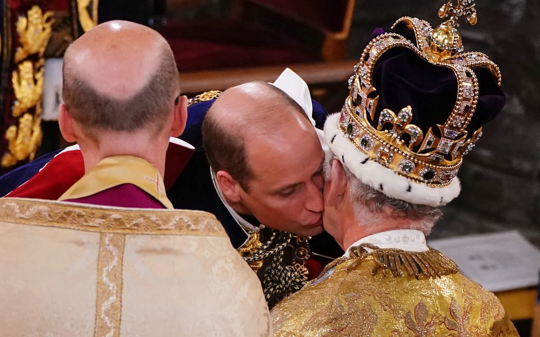 Prince William, Prince of Wales, kisses his father, King Charles III, wearing St Edward's Crown, during the Coronation ceremony inside Westminster Abbey in central London on May 6, 2023. - The set-piece coronation is the first in Britain in 70 years, and only the second in history to be televised. Charles will be the 40th reigning monarch to be crowned at the central London church since King William I in 1066. Outside the UK, he is also king of 14 other Commonwealth countries, including Australia, Canada and New Zealand. Camilla, his second wife, will be crowned queen alongside him and be known as Queen Camilla after the ceremony. (Photo by Yui Mok / POOL / AFP)