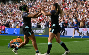 England's wing Jess Breach (R) celebrates after scoring their first try during the Women’s Rugby World Cup pool A match between England and Australia at Brighton & Hove Albion Stadium, Brighton, southeast England, on September 6, 2025. (Photo by Glyn KIRK / AFP)