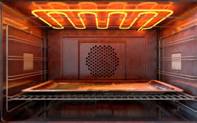 A close view inside a  hot operational household oven with an empty tanished baking tray - 3D render