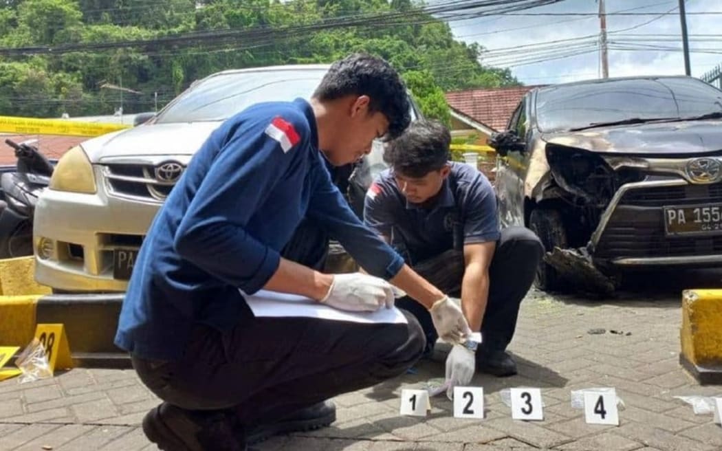 Police officers inspect the scene around the Jubi editorial office in Jayapura, Papua, after it was targeted in a fire-bomb attack, Oct. 16, 2024. [Victor Mambor/BenarNews]