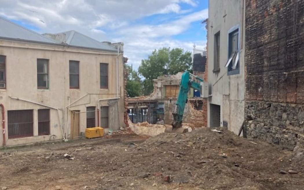 Demolition of 1860s shops in Princes St, Dunedin, and businesses nearing completion.
