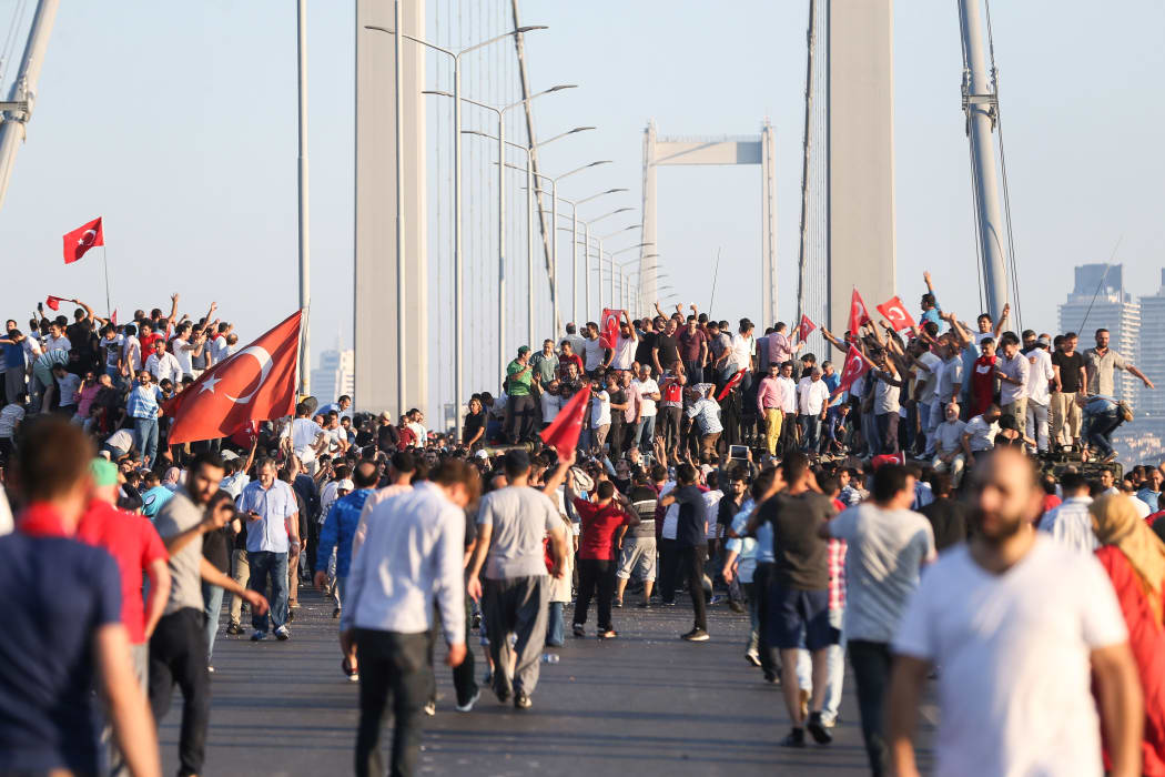 People climb on tanks after soldiers occupying Bosphorus Bridge surrendered in Istanbul, Turkey on July 16, 2016