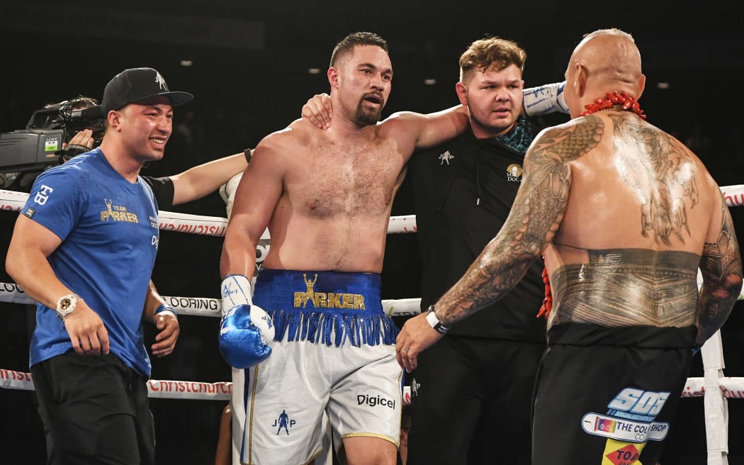 New Zealand's Joseph Parker is embraced by his brother John (left) and trainer Taylor Barry after defeating American Alexander Flores last year.
