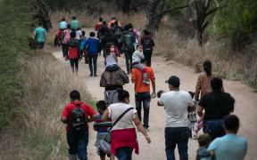 Asylum seekers, most from Honduras, walk towards a US Border Patrol checkpoint after crossing the Rio Grande from Mexico on March 23, 2021 near Mission, Texas.