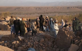 (231008) -- HERAT, Oct. 8, 2023 (Xinhua) -- People are seen among ruins of dwellings after earthquakes in Herat Province, Afghanistan, Oct. 7, 2023. At least 120 people were killed and around 1,000 others injured as earthquakes shocked Afghanistan's Herat and other western provinces, a local official from Herat told reporters. According to the China Earthquake Networks Center, two earthquakes with a magnitude of 6.2 jolted Afghanistan on Saturday. (Photo by Mashal/Xinhua) (Photo by Mashal / XINHUA / Xinhua via AFP)