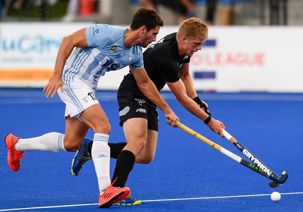 Sam Lane of the Black Sticks battles with Jose Tolini of Argentina for possession.