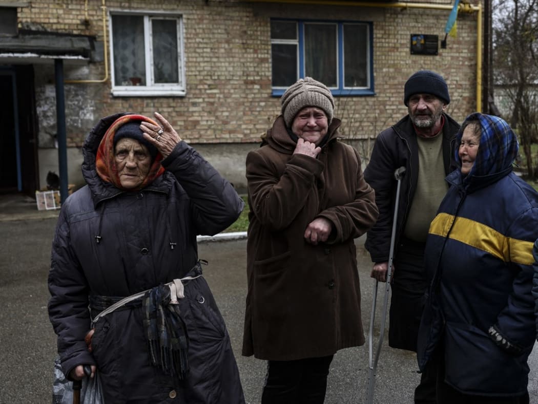 People cry outside their houses in Bucha, northwest of Kyiv, Ukraine, on 2 April, 2022. The liberated town's mayor said 280 people had been buried in a mass grave and that the town was littered with corpses following last month's invasion by Russia.