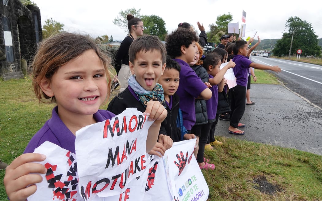 Children from Te Kura Kaupapa Māori o Taumarere line the main street in Moerewa.