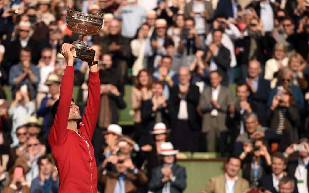 Novak Djokovic hoists the French Open trophy aloft in Paris