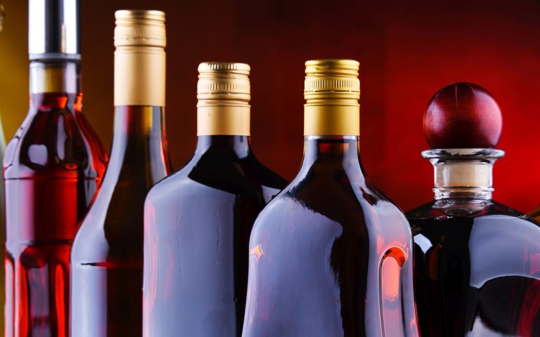 Composition with bottles of assorted alcoholic beverages.