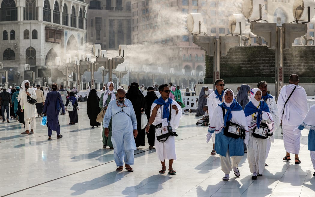 Fans blow air mixed with water vapour to cool off Muslim pilgrims walking at the Grand Mosque in Saudi Arabia's holy city of Mecca on June 4, 2024 ahead of the annual hajj pilgrimage. (Photo by Abdel Ghani BASHIR / AFP)