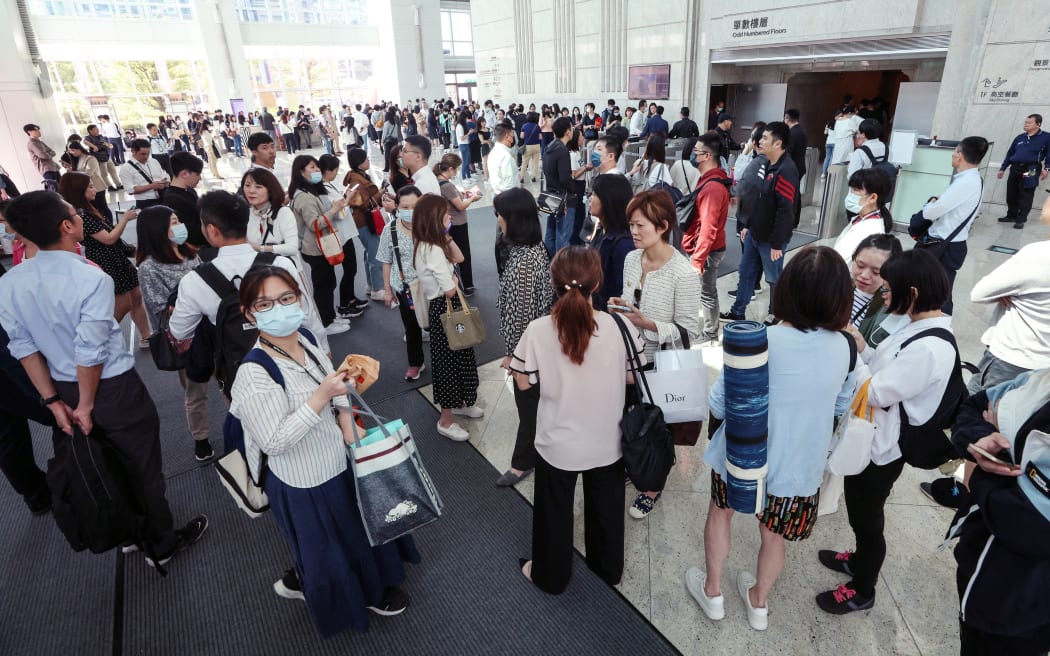 This photo taken by Taiwan's Central News Agency (CNA) on April 3, 2024 shows people gathering in the lobby of the Taipei 101 office building in Taipei, after a major earthquake hit Taiwan's east.