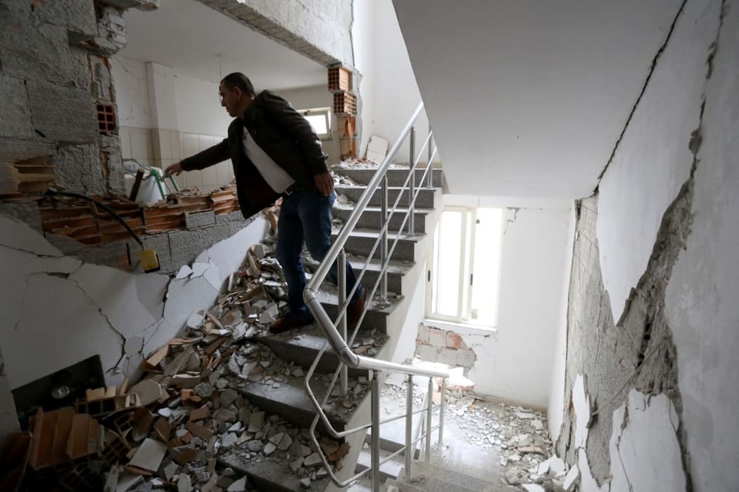 A man enters his damaged home to take his belongings in the earthquake hit city of Durres, western Albania on December 2, 2019.