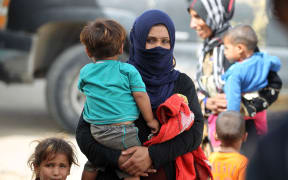 Iraqi families who fled the town of Hawija take refuge in the nearby town of Sharqat, around 80km south of Mosul.