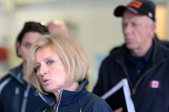 Alberta Premier Rachel Notley (left) speaks at the Fort McMurray fire department as fire chief Darby Allen looks on.