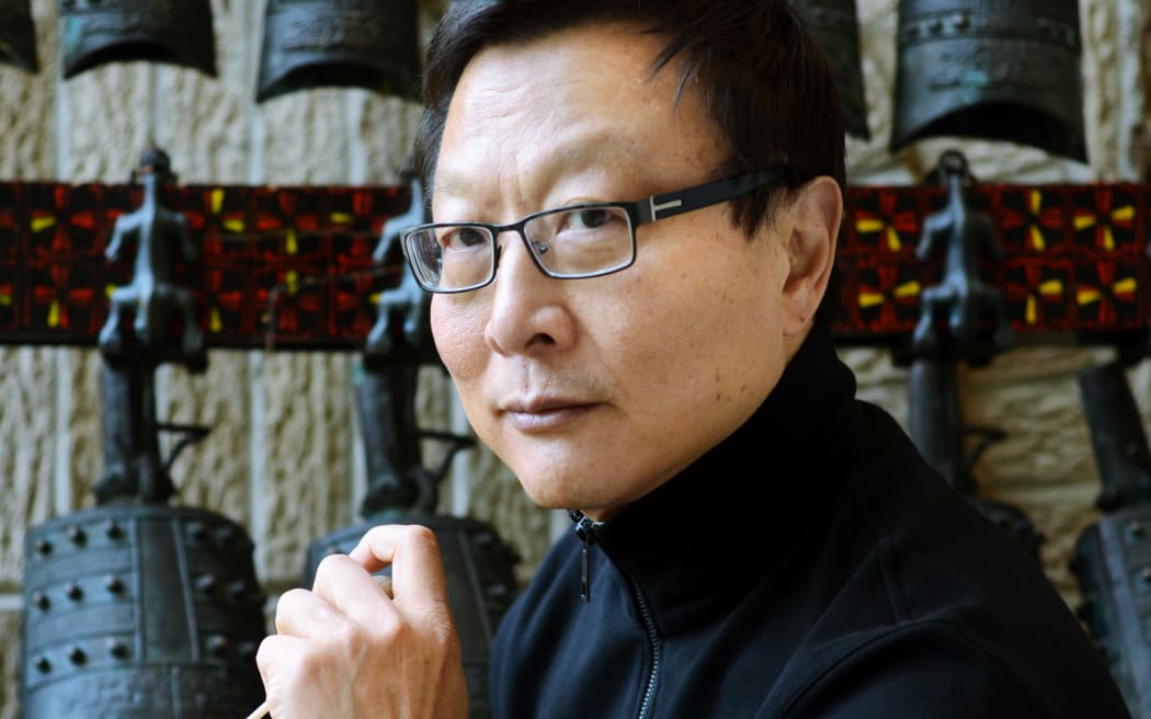 Composer/conductor Bright Sheng holding baton