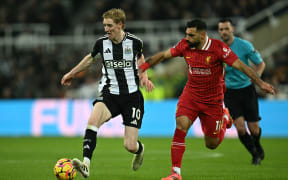 Liverpool's Mohamed Salah, right, vies with Newcastle United's Anthony Gordon during the English Premier League match at St James' Park in Newcastle-upon-Tyne,December 4, 2024.