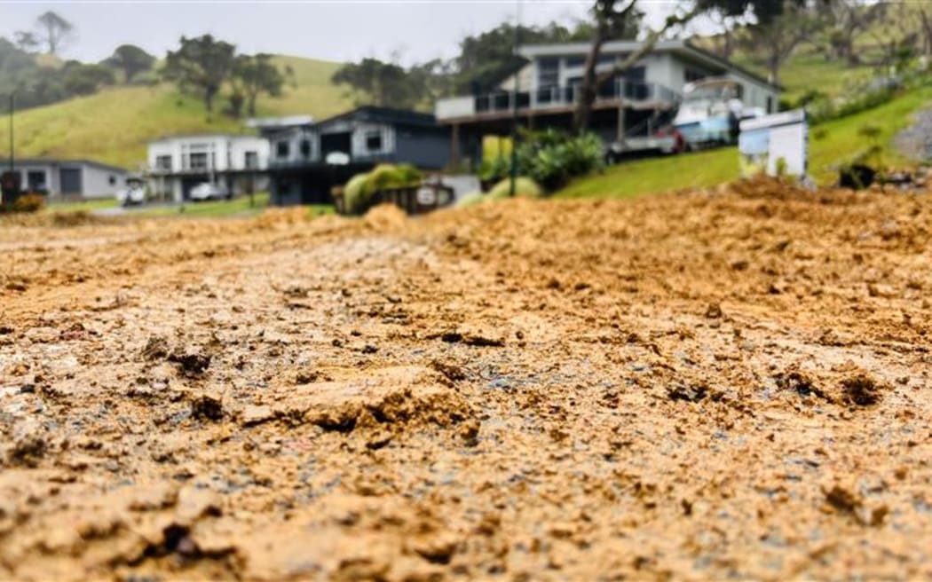 Some of the residential roads in Ōakura remain covered in thick mud.