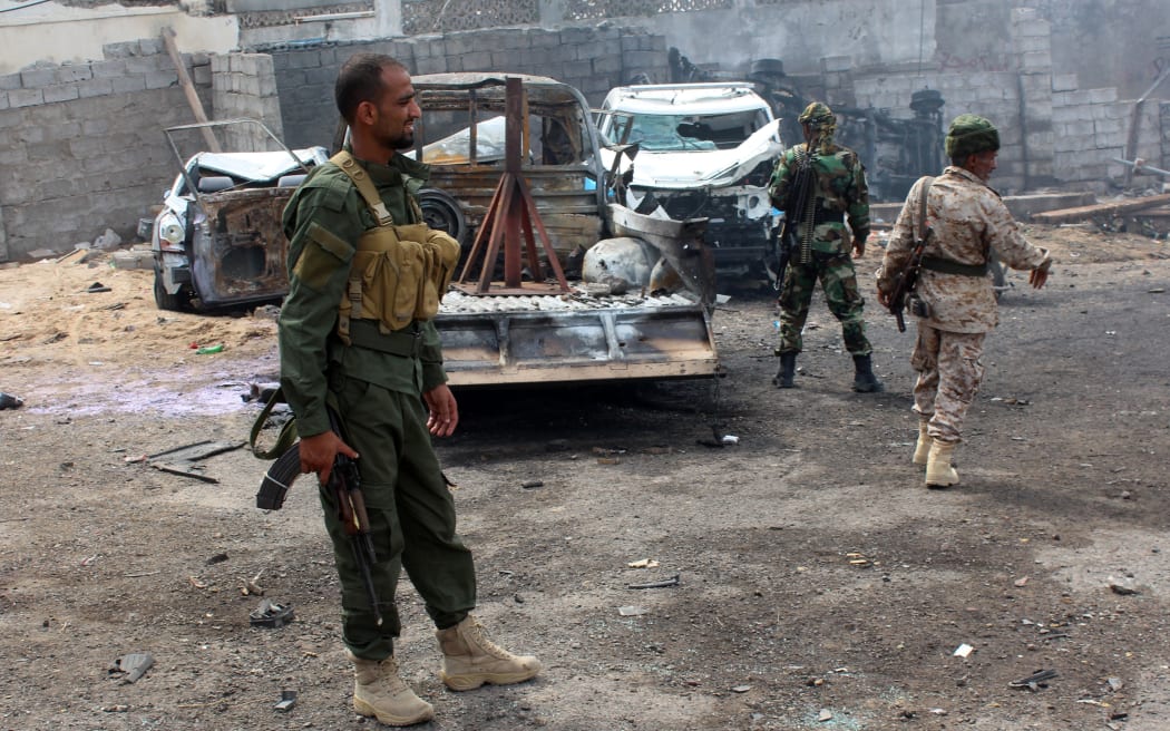 Yemeni loyalist forces gather at the scene of a suicide attack targeting the police chief in the base of the Saudi-backed government on April 28.