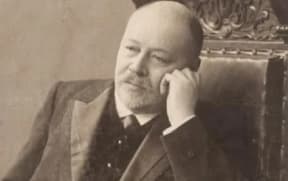 Russian composer Anatoly Liadov sitting in a chair staring off into space