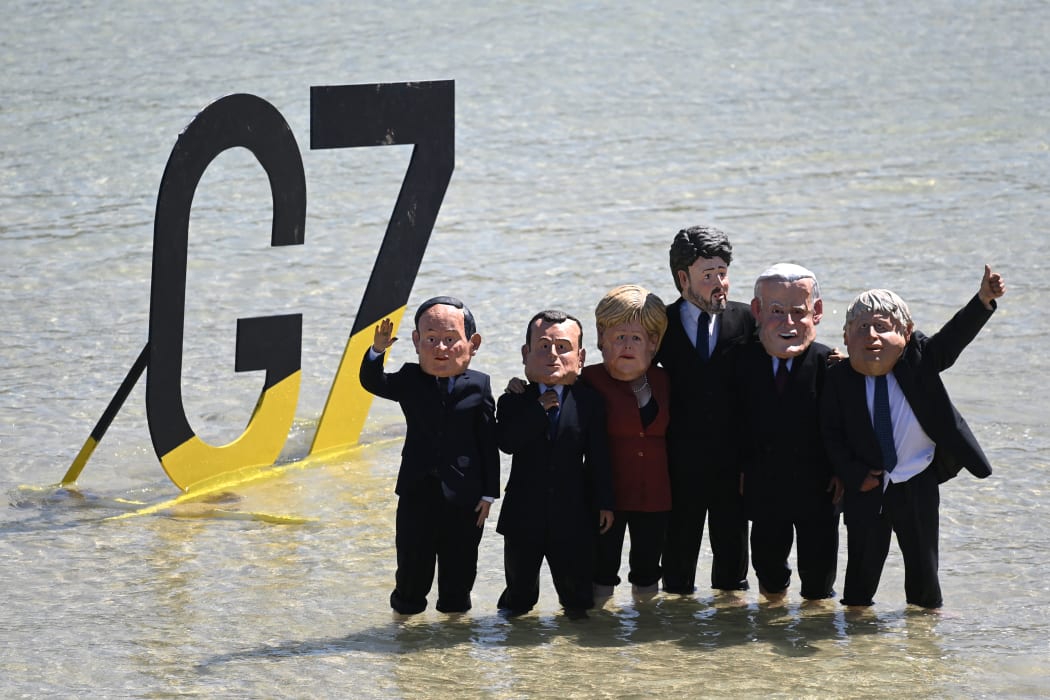 Extinction Rebellion environmental activists with masks of G7 leaders protest on the beach in St Ives, Cornwall during the G7 summit on 13 June, 2021.