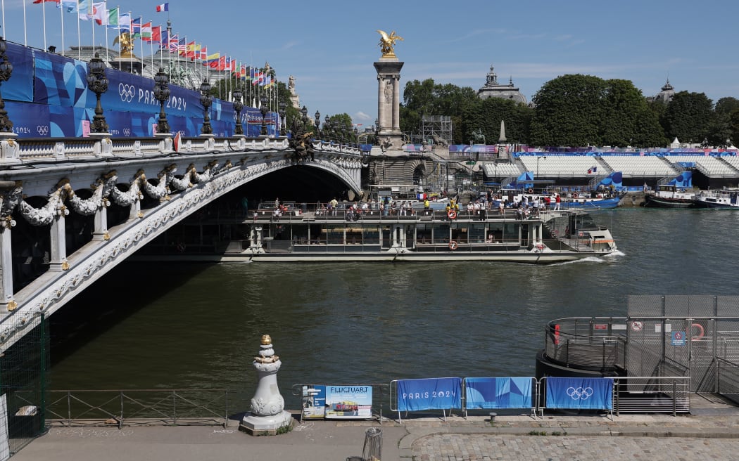 A tourist boat navigates on the Seine river under the Alexandre III bridge, after the first triathlon training session was cancelled during the Paris 2024 Olympic Games in Paris, on July 28, 2024, due to the pollution of the Seine river.