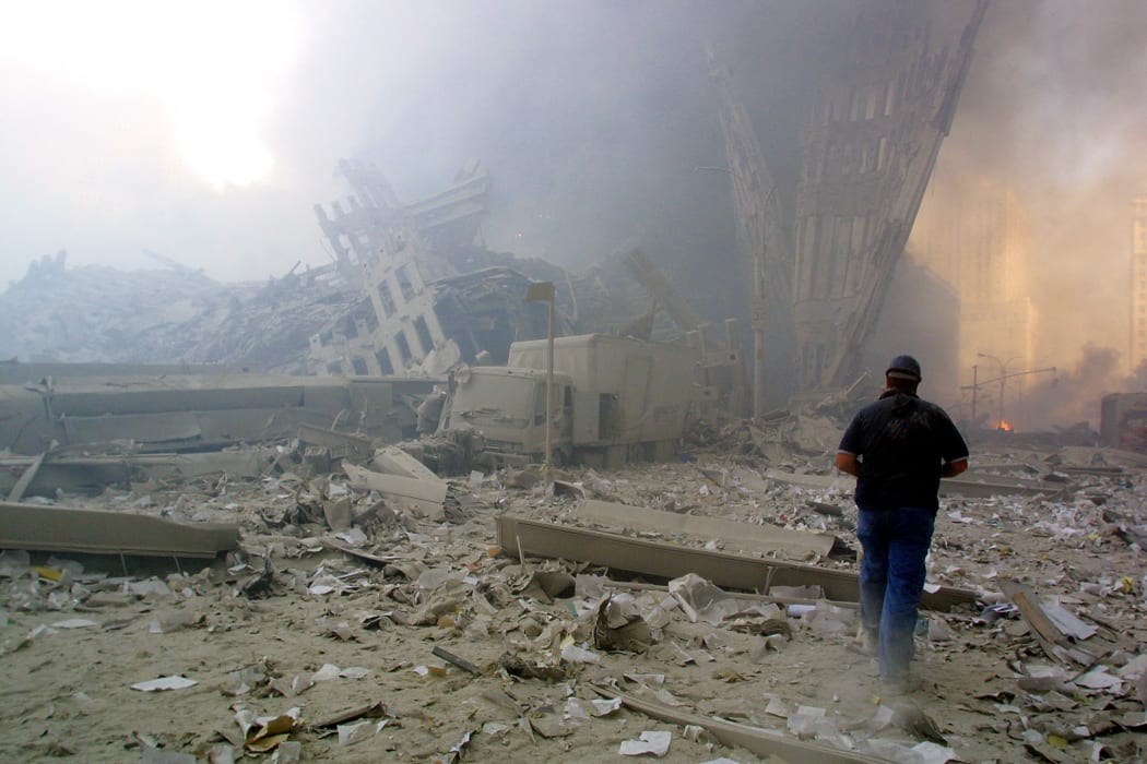 A man walks through the rubble after the collapse of the first World Trade Center tower, 11 September 2001, New York.