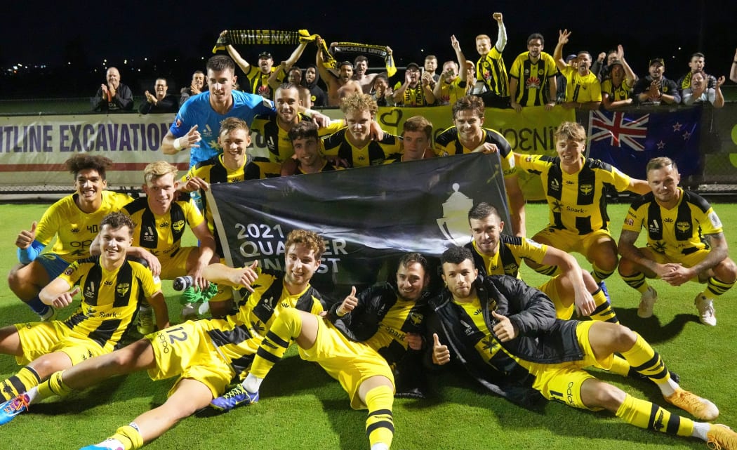 Wellington Phoenix players celebrate with the flag after winning the Round 16 FFA Cup match against Avondale FC.