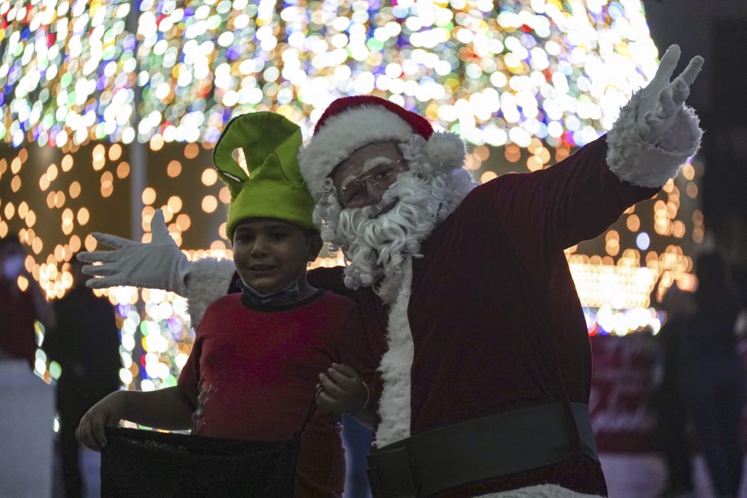 A man dressed as Santa entertains kids at the Salvador del Mundo plaza in El Salvador.