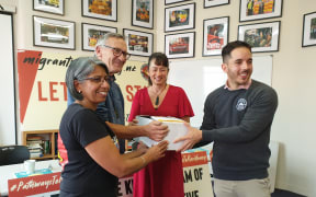 Anu Kaloti from the Migrant Workers Association and Mike Treen from the Unite Union present signatures to Labour MP Marja Lubeck and Green MP Ricardo Menéndez.