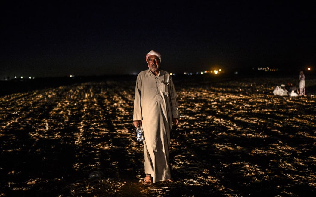 A Syrian Kurdish refugee waits after crossing the border into Turkey.