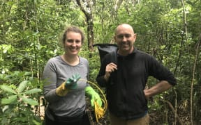 A man and a woman smiling in the forest