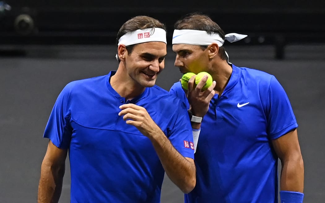 Switzerland's Roger Federer (L) gets instructions from Spain's Rafael Nadal (R) of Team Europe playing against USA's Jack Sock and USA's Frances Tiafoe of Team World during their 2022 Laver Cup men's doubles tennis match at the O2 Arena in London on September 23, 2022.