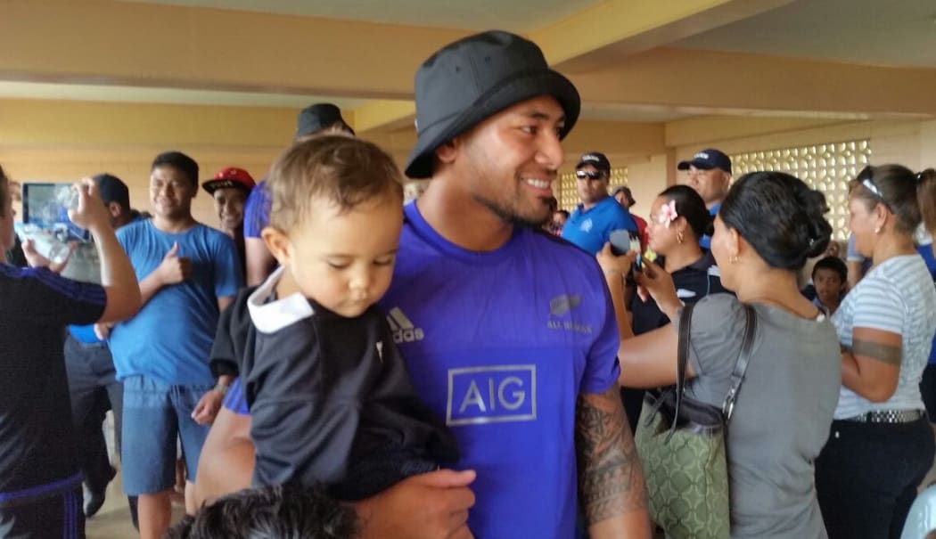 Charles Piutau and local baby Seamona.