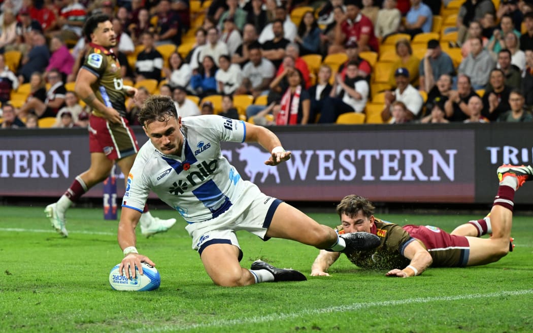 Cole Forbes of the Blues scores a try against the Reds.