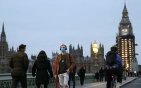 LONDON, ENGLAND - DECEMBER 16: People walking at streets wear mask due to the increase in cases of the Omicron variant of the COVID-19 in London, United Kingdom on December 16, 2021.