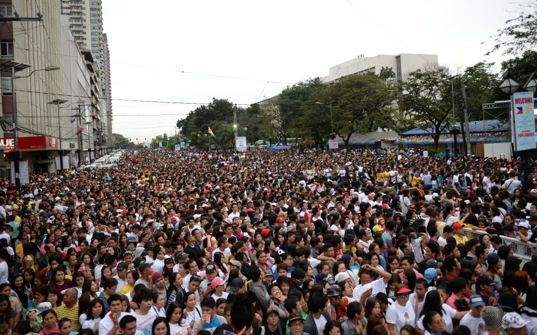 Thousands of people gather to wait for a mass to be celebrated by Pope Francis in Manila.
