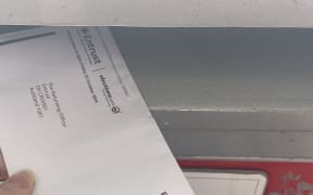An envelope going into a post office box, with an entrust logo on it.