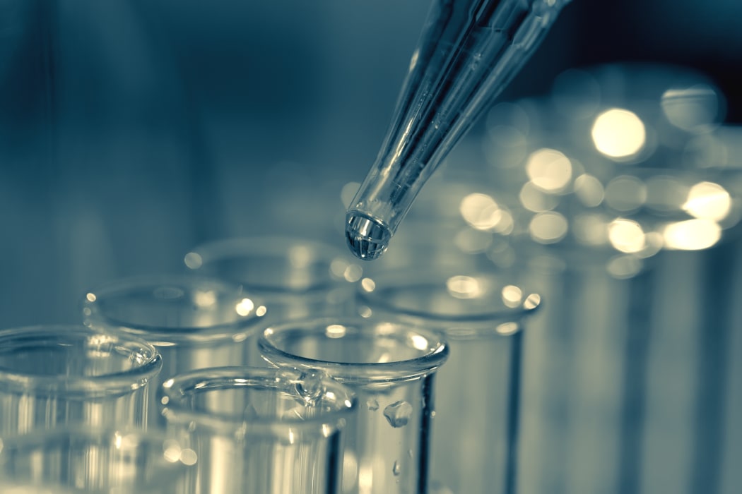 15139167 - pipette adding fluid to one of several test tubes